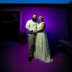 Bride and groom captured outside under string lights during a twilight wedding reception 